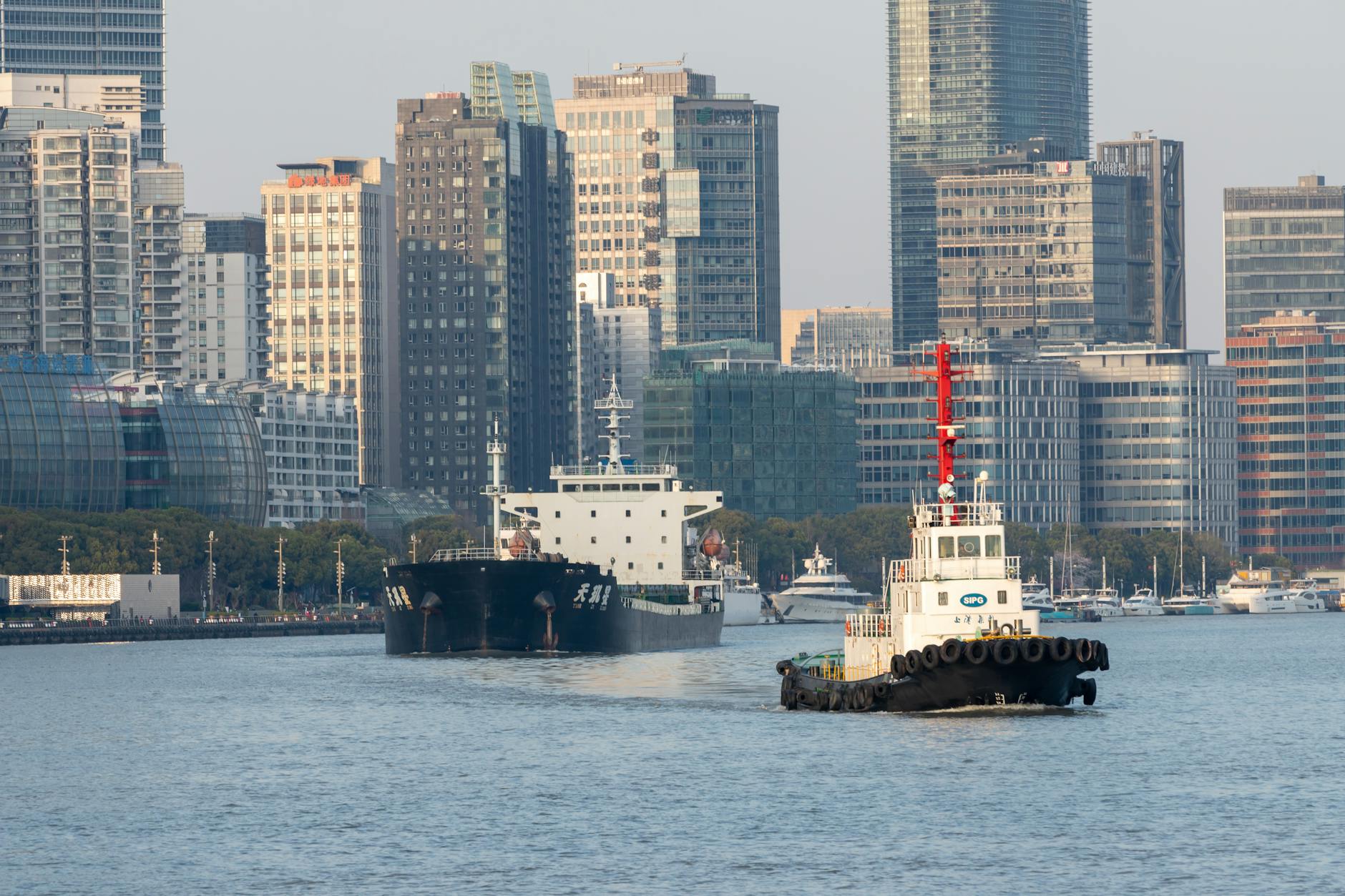 Explore the bustling waterfront of Shanghai with boats and towering modern skyscrapers.